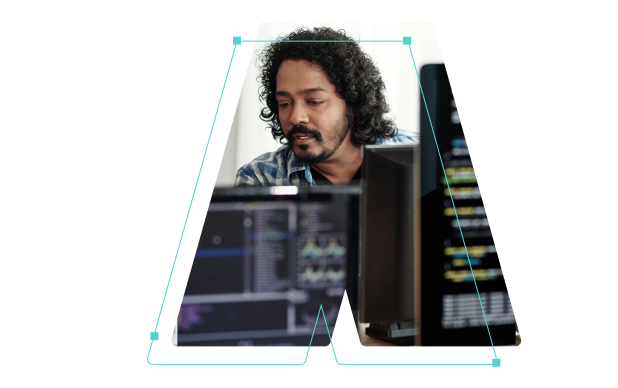 A man behind some computer monitors outlined in the shape of the letter A.