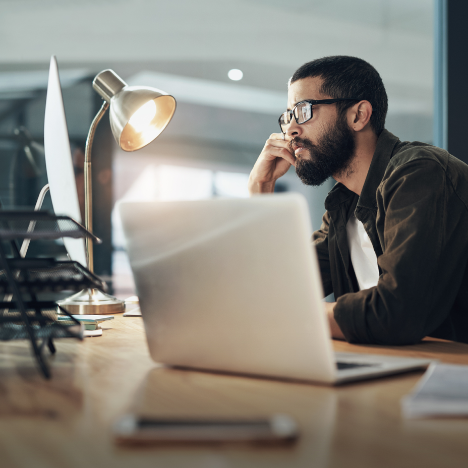A man using a computer masked by expanded T A G 1 characters.